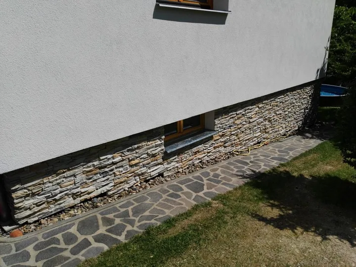 Fasáda s hladkou omítkou a kamenným soklem